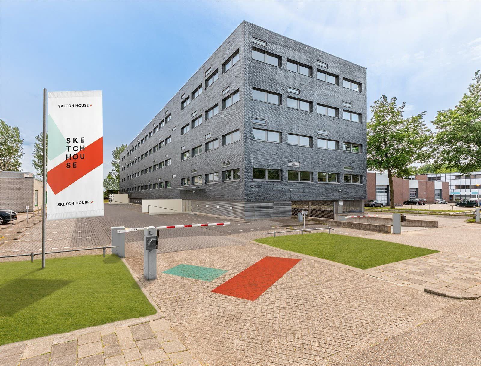Het kantoorpand aan de Randstad 22 in Almere, met de vlag bij de slagboom